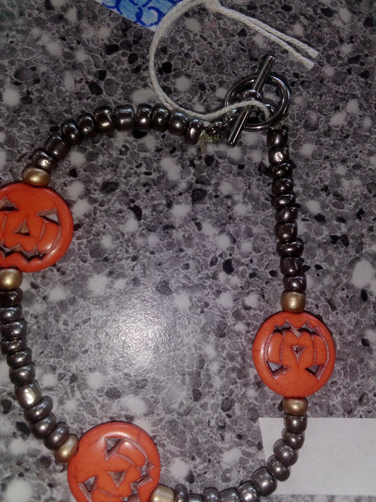 Dark seed beads and three pumpkins