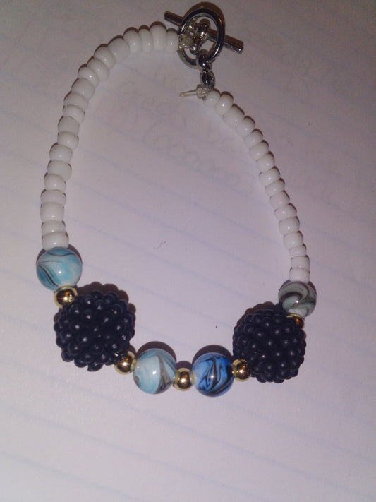 White seed beads with blue swril black lines with black spiky ball with sliver spacers