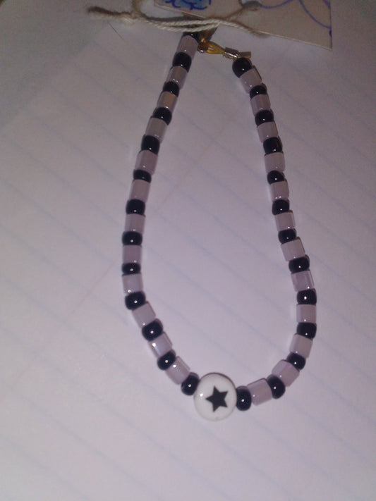 Black/light gray seed beads with white circle with black star